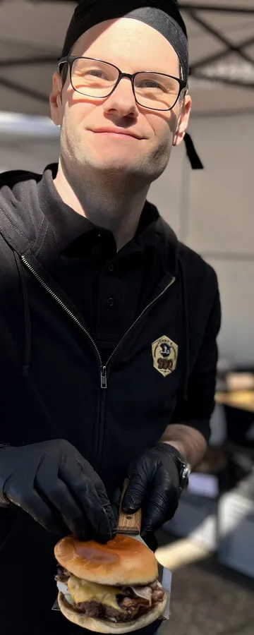 Klaus 'Jonny' Kastler lächelnd mit Burger